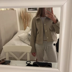 Beige jacka med fickor - Säljer en stilren beige jacka med stora fickor och knappar framtill. Jackan har en klassisk krage och långa ärmar, perfekt för en avslappnad look. Den är i en neutral färg som passar till det mesta. Perfekt för höst och vår!