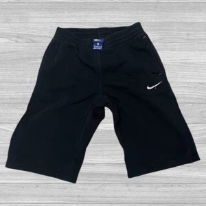 Svarta shorts från Nike - Säljer ett par svarta shorts från Nike med elastisk midja och det klassiska Nike-logotypen i vitt. Perfekta för träning eller en avslappnad dag.