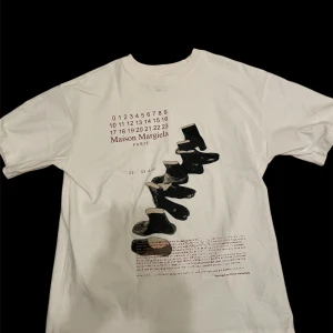 Vit t-shirt från Maison Margiela - Säljer den här vita t shirten från maison margiela för ett riktigt bra pris!  Den är perfekt nu till våren och sommaren och är en komplimang magnet                                                          📐STORLEK📐den är medium men jag skulle säga att den passar large/ small också                             💵PRIS 💵jag tycker själv 775kr är ett rimligt pris men det är inte skrivet i sten så om du har ett rimligt bud tveka inte på att skicka det! Om du har några frågor är det bara att fråga