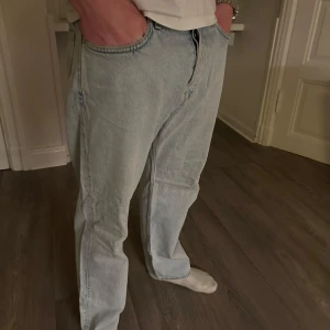 Ljusblå jeansbyxor från Weekday - Säljer ett par ljusblå jeansbyxor från Weekday med en klassisk straight fit. Byxorna har en midwaist och är tillverkade i jeansmaterial. Perfekta för en avslappnad stil.