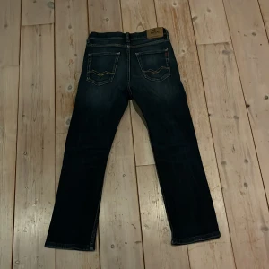 Replay jeans - Snygga mörkblå jeans från Replay med klassisk femficksdesign och knappgylf. Jeansen har en straight passform och är perfekta för en avslappnad stil. Märkesdetaljer syns på baksidan och insidan av midjan. Dem sitter bra till typ 150cm typ.