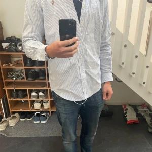 Randig skjorta från Ralph Lauren - Skjorta från Ralph Lauren med tunna blå och vita ränder. Storleken är S men skulle säga att den passar M. Mycket bra skick, bara använd ett par gånger. 