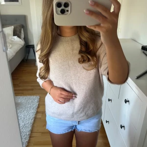 Beige stickad tröja med rund hals - Säljer en supermjuk beige stickad tröja med rundad hals och långa ärmar. Tröjan har en clean och enkel look, perfekt att matcha med jeans eller shorts. Materialet känns fluffigt och skönt mot huden, och passformen är normal med lite loose vibe. Köpt för 790kr. 