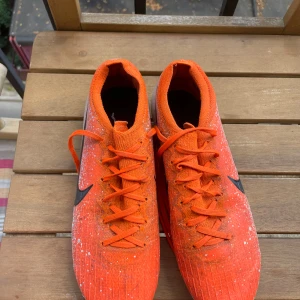 Nike mercurial Vapor 12 elite pris kan diskuteras. - Säljer ett par grymma orangea fotbollsskor från Nike med svart Swoosh på sidan. Skorna har snörning och en cool spräcklig design i vitt och orange. Yttermaterialet är syntet och sulan har dobbar för spel på gräs. Perfekt för dig som vill sticka ut på planen.
