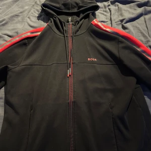 Hugo boss zip hoodie - Säljer en snygg hugoboss zip hoodie, använd endast vid 3 tilfällen. Säljer då den ej kommer till användning längre. Nytt skick med inga defekter. Äkta hugo boss.