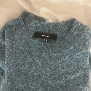 Blå stickad tröja från Vero Moda - Mysig blå stickad tröja från Vero Moda i storlek XS. Tröjan har rund halsringning och långa ärmar med ribbade muddar. Perfekt att slänga på sig när det är kyligt ute, och den har en chill, loose passform som är enkel att styla med jeans eller kjol.