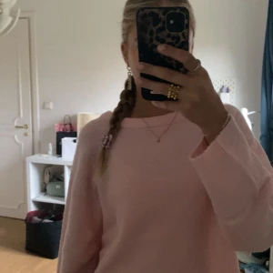 Ljusrosa stickad tröja - Säljer en supermysig ljusrosa stickad tröja med rund hals och långa ärmar. Perfekt för dig som gillar en enkel och clean look med en touch av färg. Tröjan har ribbade muddar vid ärmslut och nederkant. Passar dig som vill ha en chill och comfy stil. Storlek L men passar xs/s! 