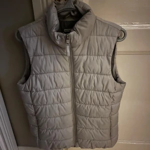 Vit quiltad dunväst med dragkedja - Vit dunväst i storlek L men väldigt liten i storleken. Jag har vanligtvis M men den passar S-M. Snygg och med normalhög krage. Perfekt nu till hösten💕 den är även i väldigt bra skick. Skriv för fler bilder☺️