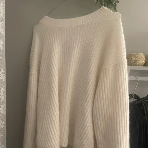 Vit ribbad stickad tröja - Säljer en vit stickad tröja med ribbad struktur. 🥰Tröjan har en loose passform, perfekt för att hålla sig varm och snygg under kyliga dagar. Enkel att matcha och i bra skick☺️☺️