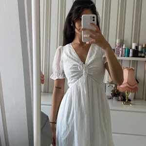 Vit kläning - Vit söt kort kläning med öppen rygg, går att knyta både på framsidan för Justera brösten och knyta en roset i ryggen