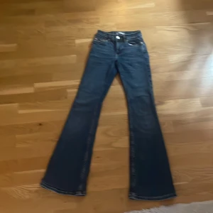 Bootcut jeans från Gina Tricot, blå - Säljer ett par snygga blå bootcut jeans från Gina Tricot, modell Perfect Jeans. Klassisk femficksdesign, med normal passform och utsvängda ben. Jeansen är gjorda i ett mjukt denimtyg med snygga kontrastsömmar och har en stilren look.