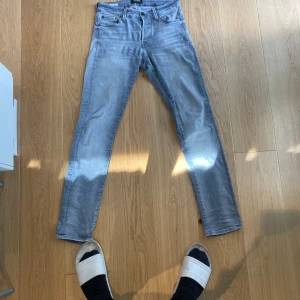 Slim Glenn ljusgrå jeans Jack & Jones - Slim Glenn jeans från Jack & Jones i en snygg ljusgrå tvätt. Modellen är slim fit med smala ben och klassisk femficksdesign. Jeansen är tillverkade i stretchigt denim för extra komfort och rörelsefrihet. Perfekta för dig som gillar en modern och clean look. 399kr