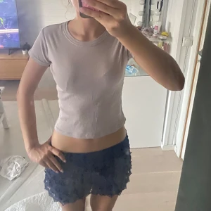 Ljusbeige/lila? croppad t-shirt Brandy Melville - Säljer en ljusgrå croppad t-shirt från Brandy Melville. T-shirten har korta ärmar, rund halsringning och sitter tight mot kroppen. Perfekt basic att styla med allt. Materialet är mjukt och stretchigt, troligtvis bomull.