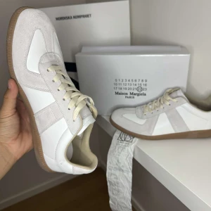 Masion margiela gats - Maison Margiela sneakers i vitt, kvitto låda och skor får man med vid köp. Skorna är 9/10 sick och är enbart lite smutsiga och repade under sulan vilket är naturligtvis meningen pris går att förhandla och skorna säljs i befintligt sick. Se sista bilden för att se kvittot. Innesulan är bytt från orginal till extra sulorna man får med när man köper dem vilket sänker priset en del! OBS: orginal sulorna finns ej kvar.