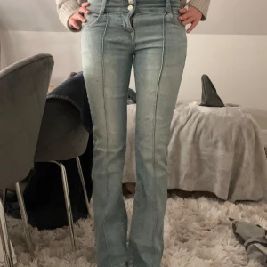 Ljusblå bootcut jeans med låg midja - Säljer ett par ljusblå jeans med hög midja och bootcut passform från Bershka. Jeansen har markerade sömmar framtill, dubbla knappar. Mera bilder via privat!🌸