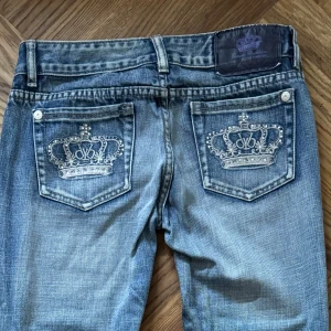 Victoria Beckham x Rock & Republic jeans - Snygga blå jeans från Victoria Beckham x Rock & Republic med broderade kron-detaljer på bakfickorna. Fattas några diamanter på baksidan (skriv privat för fler/bättre bilder då jag inte kan lägga fler än 5 bilder i annonsen) ⚠️ . Står storlek 27 men jag som vanligtvis har den storleken så är jeansen alldeles för små och går  inte att knäppa.  Mått finns på 4e bilden. Innerbenslängden är ca 79cm. 💙skriv för fler frågor! 