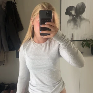 ljusgrå långärmad - inte tajt och skulle passa på strl s