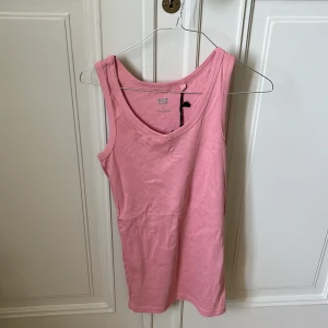 Rosa linnetopp från 157 - En enkel och snygg rosa linnetopp från 157 i mjuk bomull. Modellen är ärmlös med klassisk rund halsringning och rak passform. 