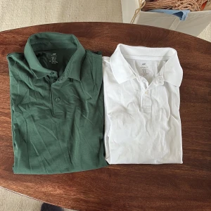 Två pikétröjor från H&M, grön & vit - Säljer två klassiska pikétröjor från H&M i storlek M båda två. En är grön och den andra är helvit, båda med krage och knappar framtill. Perfekta för en clean och stilren look. Tillverkade i mjuk bomull som känns skön mot huden.