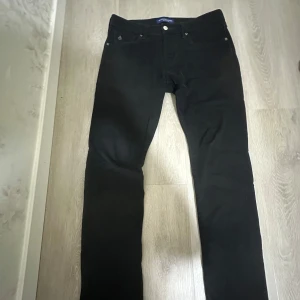 Svarta raka byxor i bomull från scoth soda - Svarta byxor med klassisk femficksdesign och raka ben. Snygg och enkel modell som passar till det mesta. Tillverkade i mjuk bomull för en bekväm känsla. Perfekta för dig som gillar stilrena och tidlösa plagg.