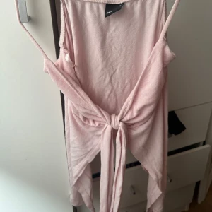 Ljusrosa linnetopp med knyt - Supersöt ljusrosa linnetopp från Gina Tricot med smala axelband och snygg knytning framtill. Toppen är ärmlös och har en croppad passform 