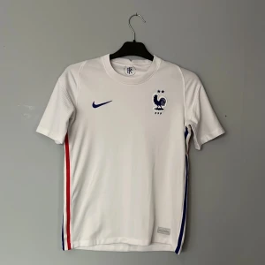 Fotbollströja  - Säljer en vit fotbollströja från Nike. Tröjan är i storlek 160-155 passar även mindre. Skick 6/10 skada på sida 4 som ni kan se. Bara att skriva för eventuella frågor. 