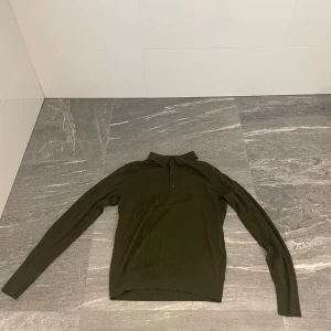 Olivgrön pikétröja från Uniqlo XS - Säljer en olivgrön långärmad pikétröja från Uniqlo i storlek XS. Tröjan har klassisk krage och knäppning med tre knappar framtill. Merino ull som passar i alla olika väder och tider på året! Tveka inte på att höra av dig vid minsta funderingar!