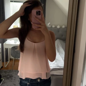 Ljusrosa topp med tunna axelband🩷 - 🩷 Supersöt ljusrosa linnetopp med tunna axelband och dubbla lager för en flowy look.  🩷Toppen har en lätt v-ringning framtill och en snygg detalj i ryggen med smal öppning.  🩷Perfekt för varma dagar och enkel att styla med jeans eller kjol. 🩷Fint skick 🩷Pris går att diskutera 🩷Postar snabbt