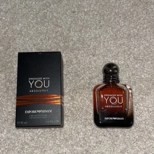 Stronger With You Absolutely 50ml - Emporio Armani Stronger With You Absolutely, 50 ml parfym för honom. Flaskan är fyrkantig med rundade kanter i glas med en mörkbrun till svart toning och svart rund kork. Snygg svart kartong med kopparfärgade detaljer. En modern och elegant doft.KVITTO FINNS 