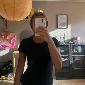 Svart ribbad topp från BikBok - En svart ribbad topp från BikBok i storlek S. T-shirten har rund halsringning och korta ärmar. Den ribbade strukturen ger en snygg och enkel look som är lätt att matcha med olika outfits.