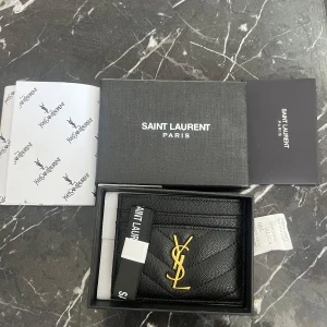 Svart plånbok från Saint Laurent - Exklusiv svart plånbok från Saint Laurent Paris i  skinn med quiltad struktur. Plånboken har flera kortfack och stilren design, perfekt för dig som vill ha något lyxigt och tidlöst. Oanvänd!!