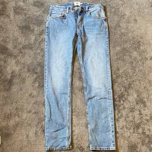 Slim fit jeans från 157, blå - Snygga slim fit jeans från 157 i klassisk ljusblå denim. Modellen heter Slimmy och har fem fickor, dragkedja och knapp i midjan. Perfekta för dig som gillar en smalare passform och enkel stil.