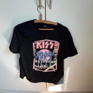 Svart KISS band t-shirt med tryck - Cool svart t-shirt från H&M med färgstarkt KISS-tryck och japanska tecken på framsidan.  Storlek L
