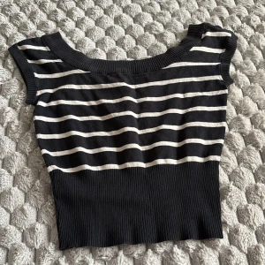 Randig croppad topp från Divided - Snygg svart och vit randig croppad topp från Divided. Toppen har bred ribbad nederkant, korta ärmar och rundad halsringning. Perfekt att styla med jeans eller kjol för en chill look.