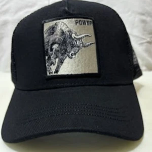 Svart truckerkeps med tjurpatch - Svart truckerkeps med böjd skärm och mesh baktill för extra ventilation. Framtill sitter en fyrkantig patch med en broderad tjur och texten 'POWER' i svart. Justerbar snapback för perfekt passform. Snygg och cool accessoar för dig som gillar statement-detaljer.