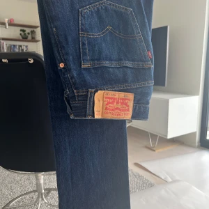 Levi's 501 mörkblå jeans straight fit - Klassiska Levi's 501 jeans i mörkblå denim med raka ben och normal passform. Byxorna är lite styvare och ger mer en dressad känsla!