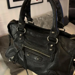 Ballenciaga liknande väska - Säljer denna superfina ballenciaga liknande väskan då den inte kommer till användning längre, har bara korta band, väldigt rymlig inuti. Enda defekten är dragkedjan på framsidan som är lite rostig💞bara att höra av sig vid funderingar