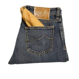 Blå jeans från Jacob Cohen - Snygga blå jeans från Jacob Cohen med klassisk femficksdesign och raka ben. Jeansen har tydliga kontrastsömmar, knäppning med knappar och patch i läder baktill. Tillverkade i mjukt bomullsjeansmaterial som ger en skön känsla hela dagen.