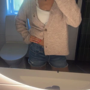 Blå jeansshorts med fransig kant - Snygga blå jeansshorts med fransig kant nertill och dubbla knappar i midjan. Klassisk femficksmodell och normal passform. Perfekta till sommaren och lätta att matcha med allt.använd endast en gång!är storlek 164 som motsvara typ xxs eller xs