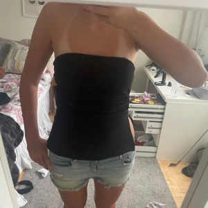 Svart tubtopp - Säljer en svart tubtopp med tight passform och slits på båda sidor. Den går även att styla med allt möjligt. 