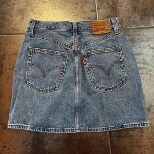 Levi's jeanskjol med knappar - Enkel Levis jeans kjol med knappar i ”Levis storlek” 26 vilket motsvarar en storlek på 34-36 