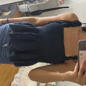 Mörkblå smockad linnetopp från SHEIN - Supersöt mörkblå linnetopp från SHEIN med smockad överdel och volangig nederdel. Axelbanden knyts på axlarna för en extra gullig touch. Perfekt till jeanskjol eller shorts när det är varmt ute!