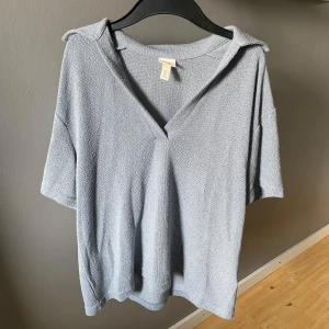 Ljusblå stickad pikétröja  - Ljusblå stickad pikétröja från H&M med korta ärmar och v-ringning