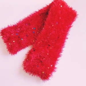 Röd glittrig fluffig halsduk - Supermjuk och fluffig röd halsduk med glittriga paljetter som ger extra wow-känsla. Perfekt accessoar för dig som vill sticka ut och addera färg till din outfit. Halsduken är lång och har en riktigt cozy känsla.  Helt & fint skick