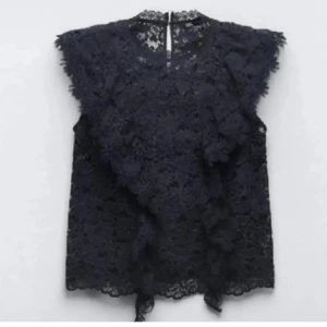 Zara spets blus - Supersnygg marinblå blus i spets med volangdetaljer framtill och ärmlös design. Perfekt för dig som gillar romantiska vibes och vill sticka ut lite extra. Blusen har hög hals och fina spetskanter som ger en lyxig känsla. Skriv om ni har några frågor eller vill ha några bilder💞💞