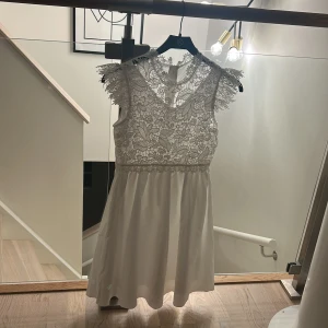 Vit spetsklänning med blommönster -  Vit klänning med spetsdetaljer 