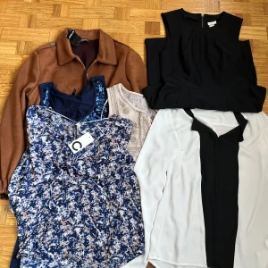 Mix av blusar och toppar i olika färger - Säljer ett gäng snygga toppar: en vit blus med svart panel och lång ärm, en svart ärmlös topp med struktur, en beige spetsblus med broderi, en marinblå topp med paljettdetaljer och en blommig blå/vit linnetopp. Perfekt för dig som vill variera stilen!