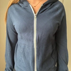 Mörkblå zipup hoodie - Mörkblå hoodiejacka från 157 med dragkedja framtill och två fickor. Jackan har en klassisk huva och är tillverkad i mjuk bomull. Säljer på grund av att den inte kommer till användning. Pris kan diskuteras!❤️