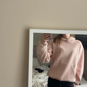 Ljusrosa hoodie från H&M - Säljer en ljusrosa hoodie från H&M i storlek 158/164. Tröjan har en klassisk känguruficka framtill, huva och en relaxed passform. Perfekt för dig som gillar en enkel och stilren look. Materialet är mjukt och skönt.