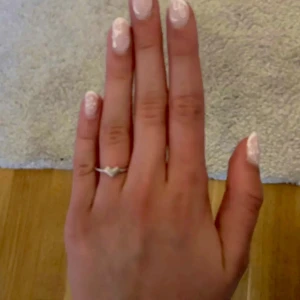 Tunn silverring med ett hjärta - Säljer en elegant ring i silverfärg med ett hjärta på. Passar fint att bära ensam eller att kombinera med andra ringar. Aldrig använd, bara testad ❤️